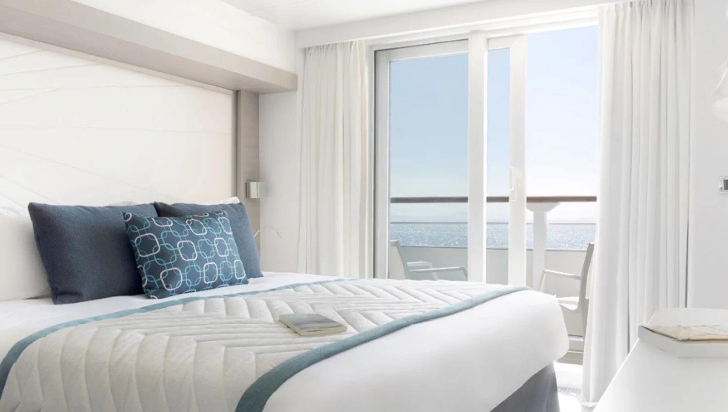 Photo de l'intérieur luxueux d'une chambre d'un yacht de croisière de Ponant, avec vue sur le ciel dégagé