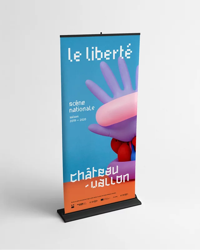 Kakémono de la Scène Nationale Châteauvallon-Liberté, avec une photo d'une composition mêlant des objets colorés formant une main