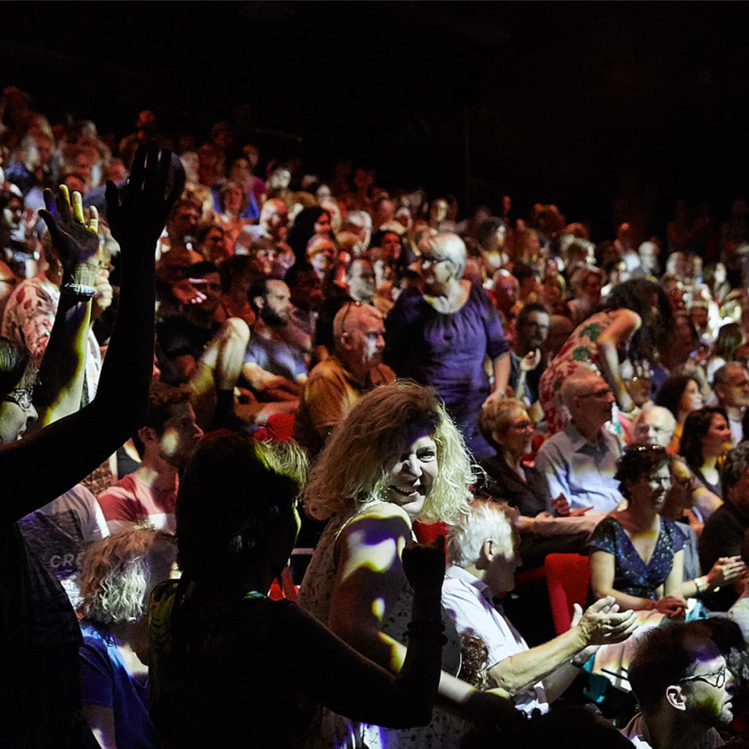 Public joyeux du festival d'avignon, la nuit, avec une dame blonde au centre