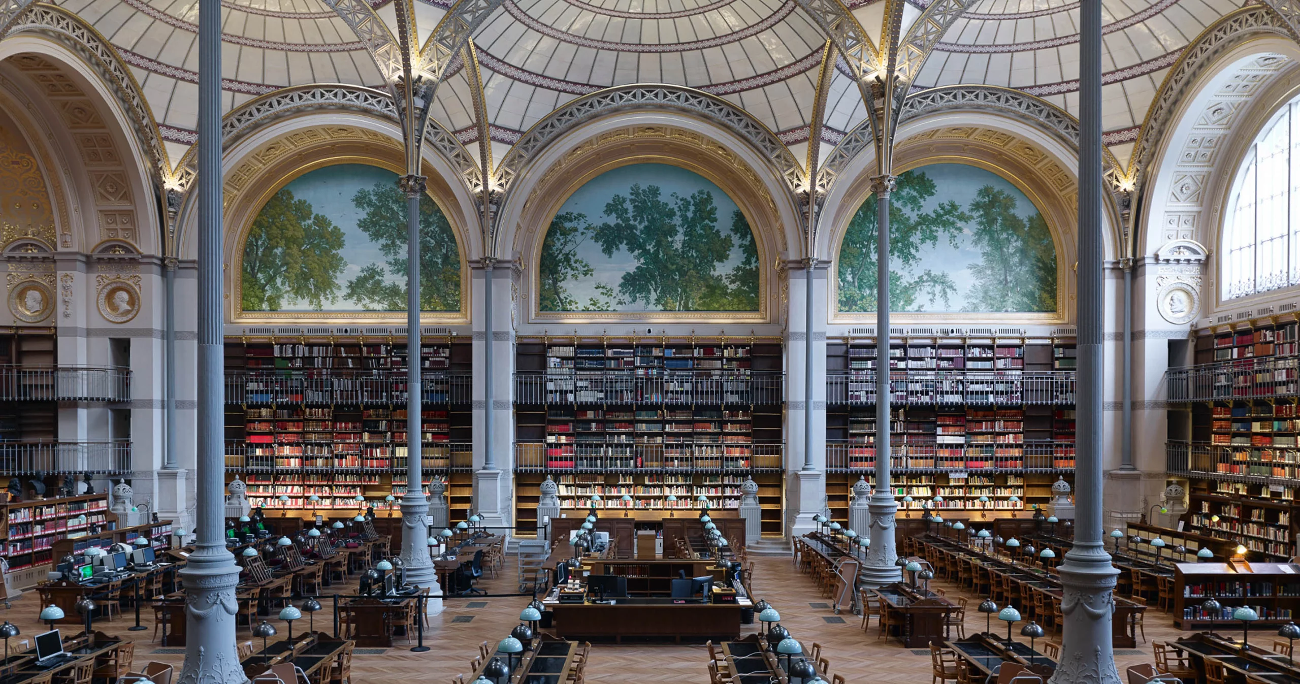 Photo de l'intérieur d'une immense bibliothèque, très spacieuse et avec des arches internes (Site Richelieu de la Bibliothèque Nationale de France)