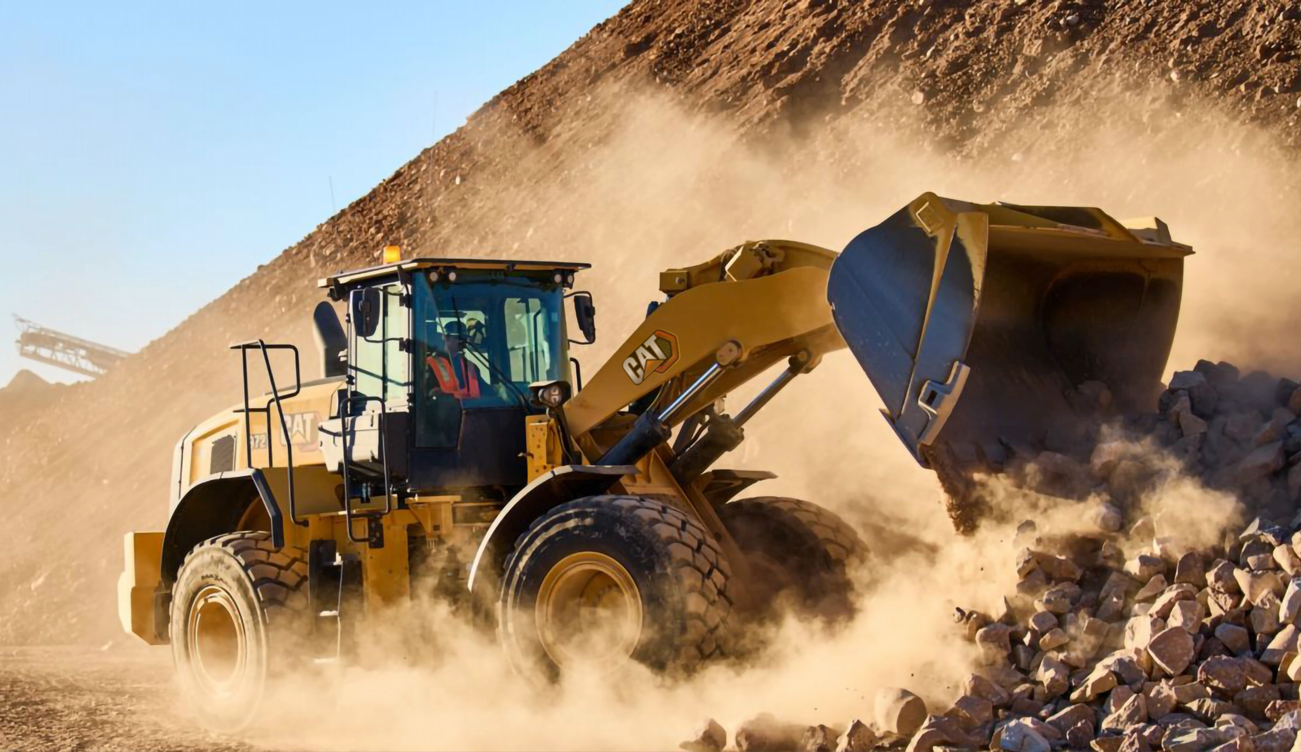 Machine Caterpillar qui déplace des pierres, dans la poussière de sable